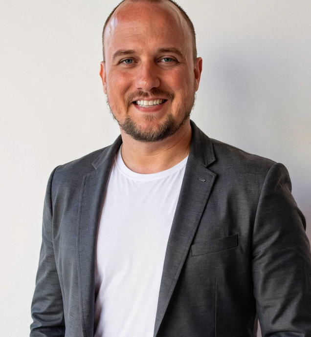 Professional smiling man in a blazer, representing Captyx, a business brokerage and M&A advisory firm, emphasizing expertise in business transactions.
