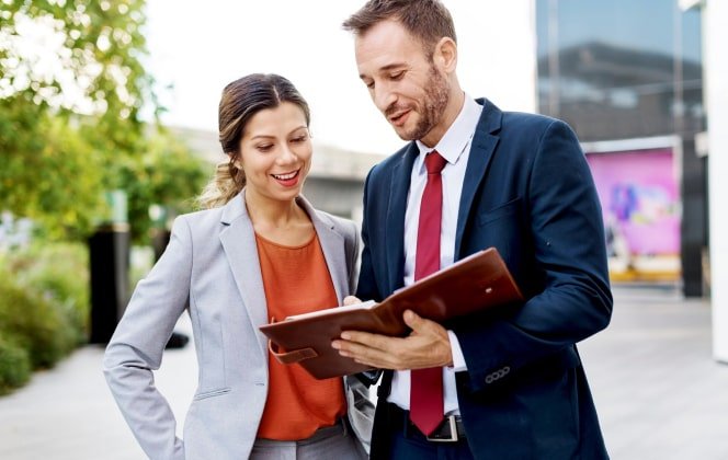 Business professionals discussing a document outdoors, representing Captyx's business valuation and advisory services.