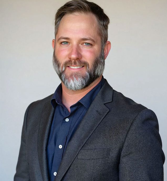 Professional portrait of a man with a beard, wearing a dark blazer and navy shirt, representing the Captyx team and their expertise in business brokerage and M&A advisory services.