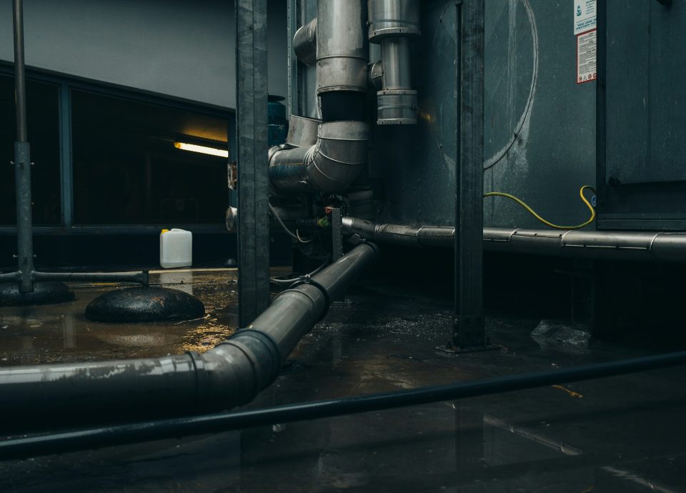 Industrial plumbing setup with pipes and machinery in a commercial setting, relevant to Captyx's business brokerage services in HVAC and plumbing industries.