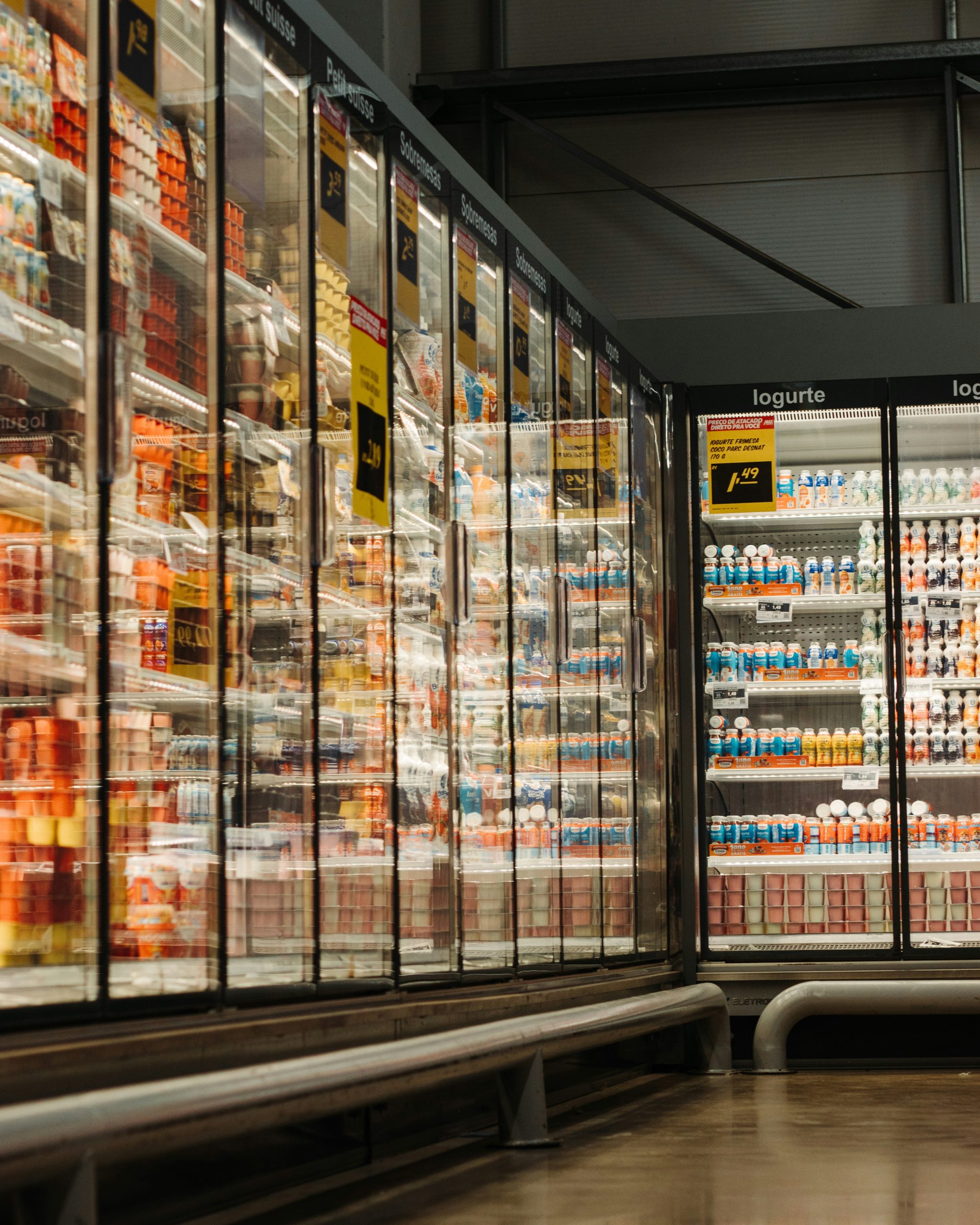 Refrigerated aisles in a convenience store showcasing various packaged food and beverage products, highlighting the importance of inside sales and product diversity in convenience store valuations.