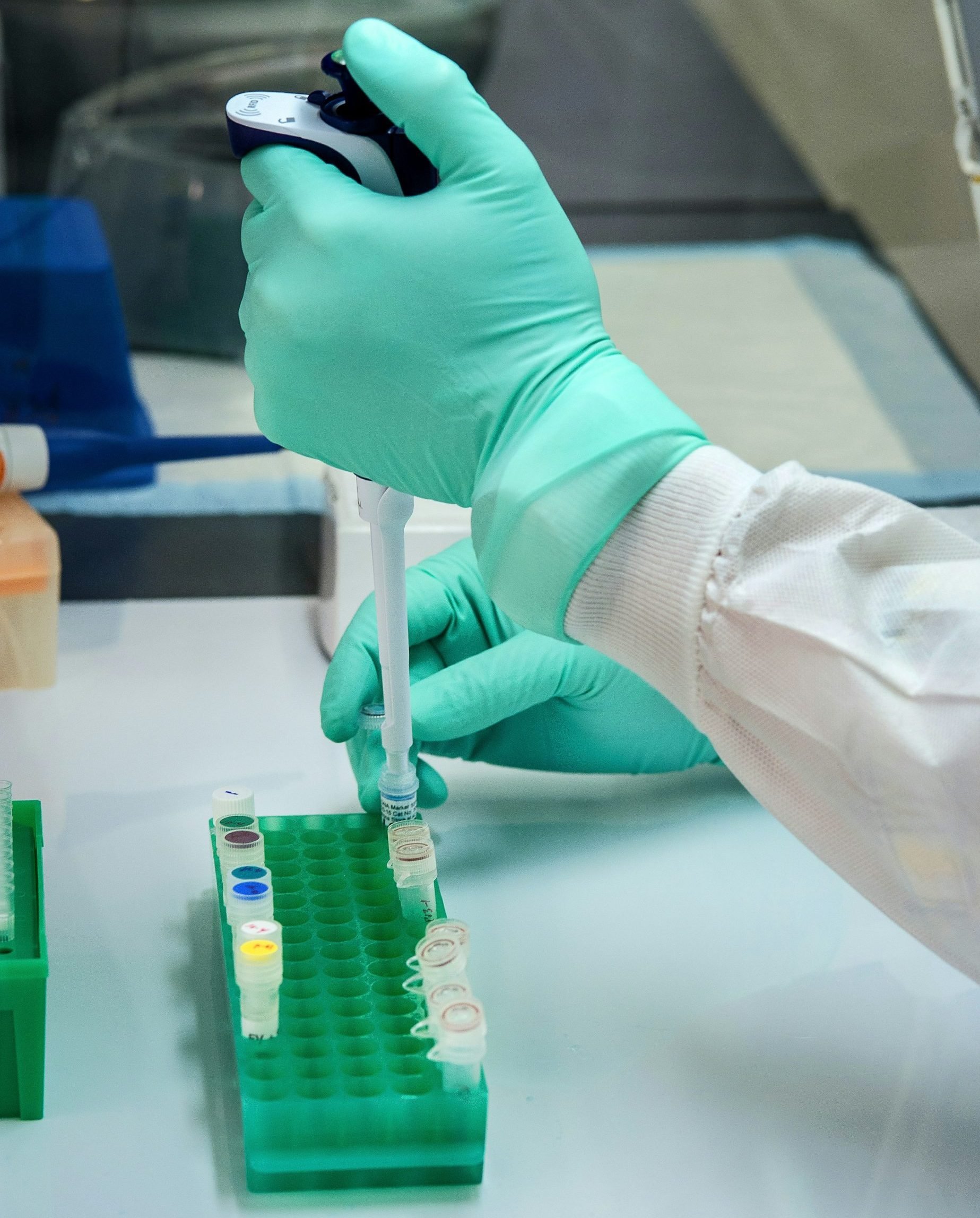 Laboratory technician using a pipette to transfer samples into test tubes, emphasizing precision in healthcare business evaluations.