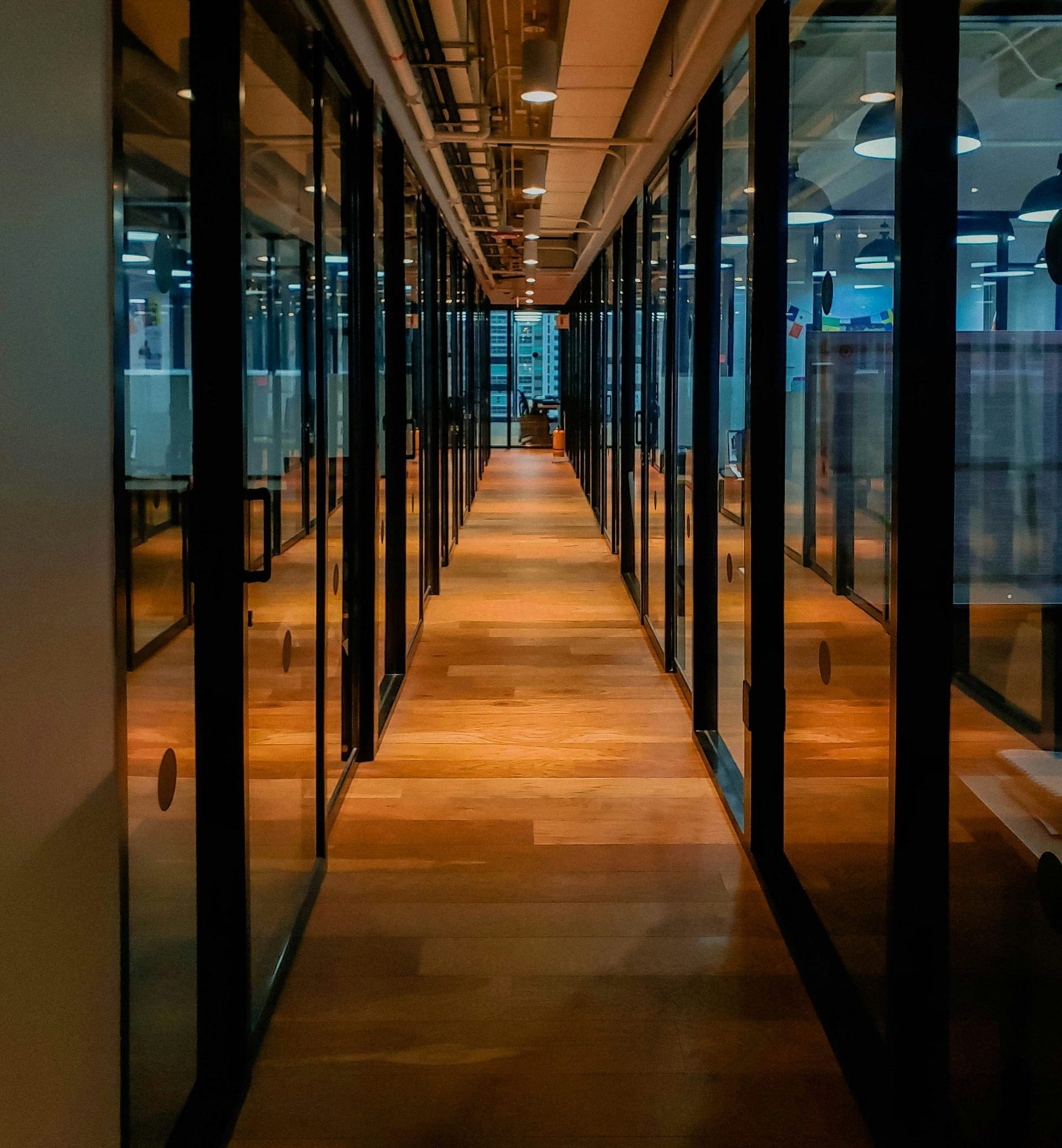 Modern office corridor with glass meeting rooms, showcasing a professional environment for software business valuations and strategic consultations.