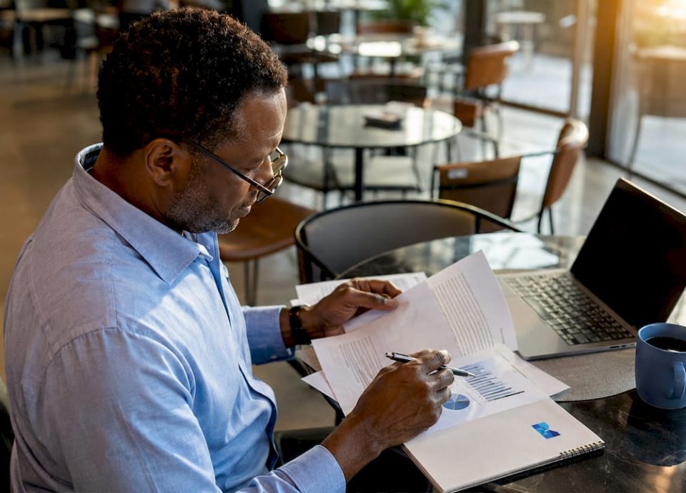 Man reviewing small business sale documents at home