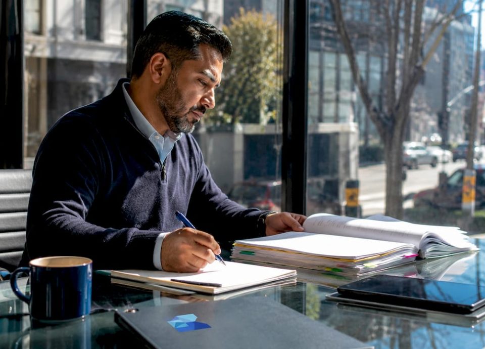Business broker reviewing client files at desk