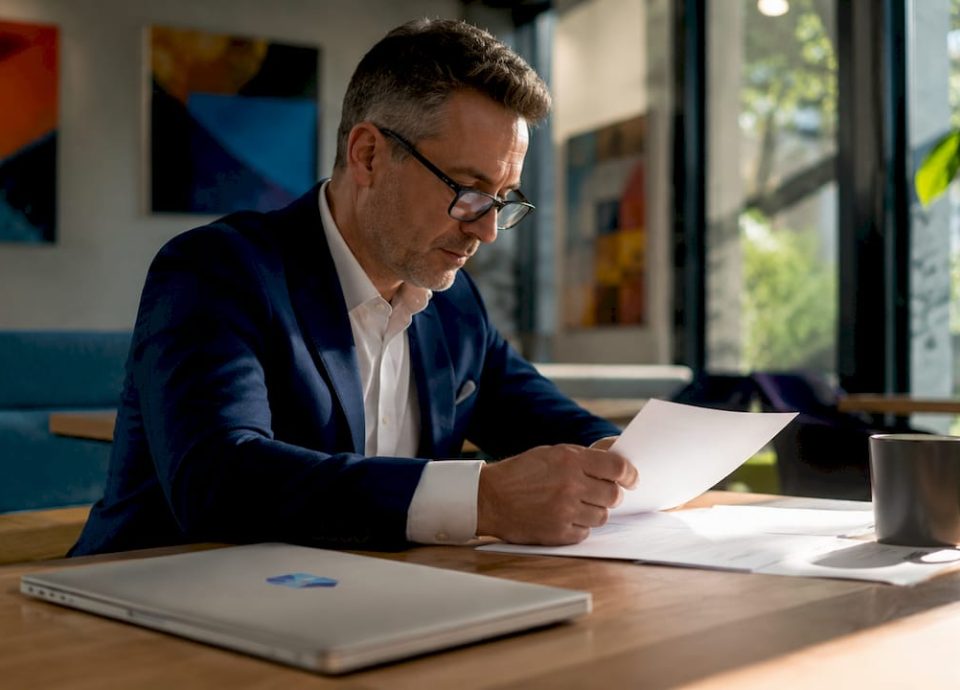 Entrepreneur reviewing acquisition proposals in office