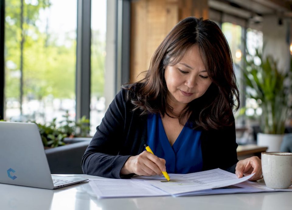 Businesswoman reviewing acquisition thesis documents