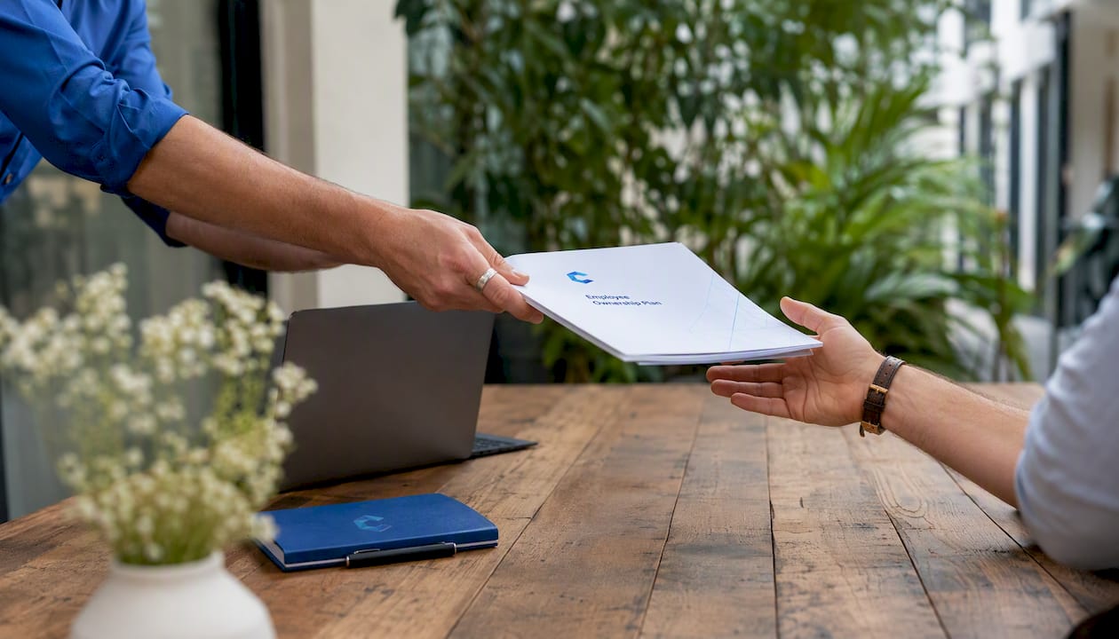 Hands exchanging ESOP documents in meeting