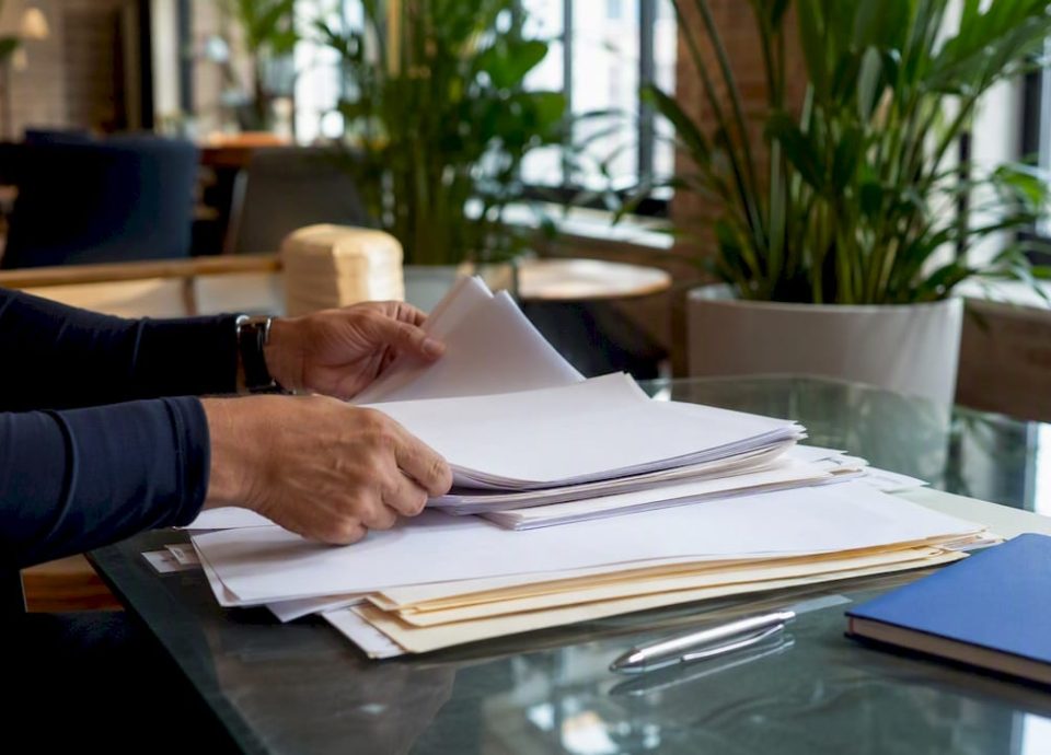 Hands organizing financial documents on office desk