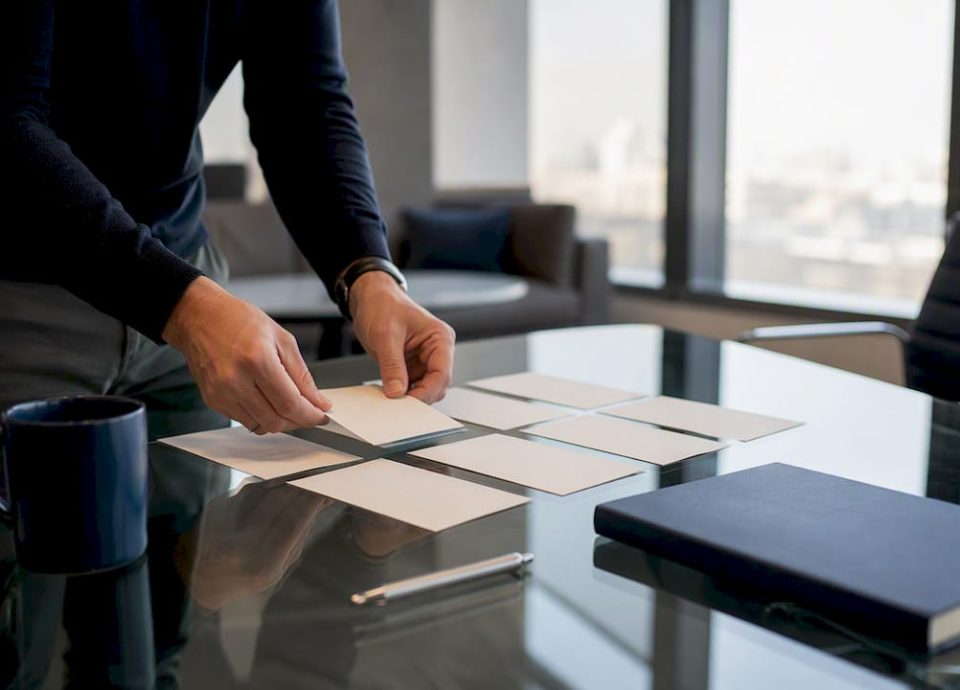 Hands organizing consulting deliverable cards