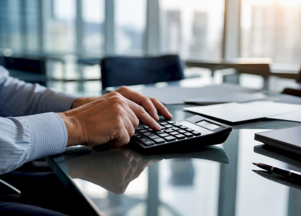 Hands using calculator on office desk