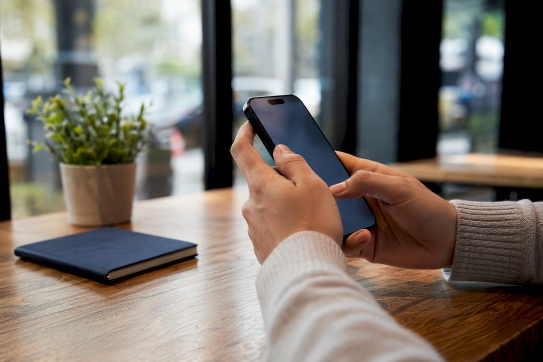 Hands verifying buyer’s proof of funds on phone