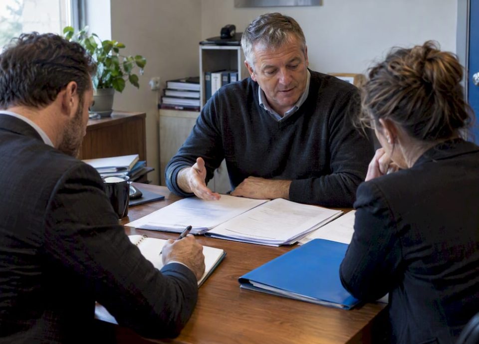 Owner reviewing business sale records with buyer